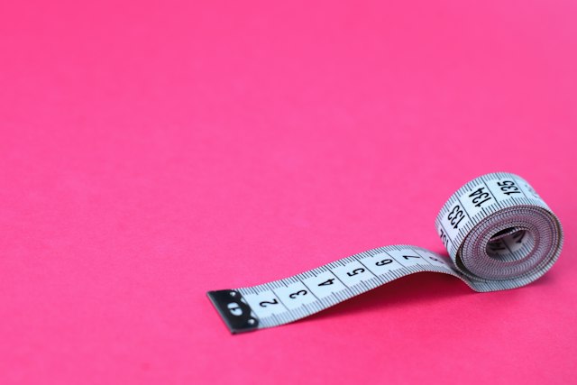Photograph: measuring tape on a pink background