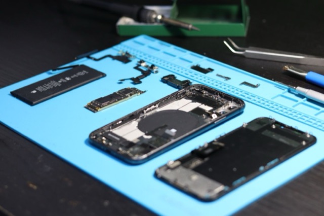 Photograph: disassembled smartphone with tools, refurbishing theme