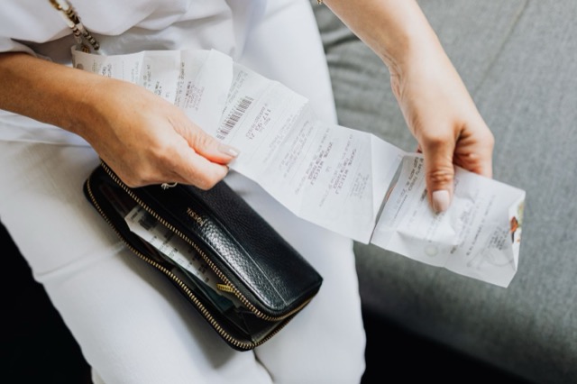 Photograph: hands sorting receipts from a wallet