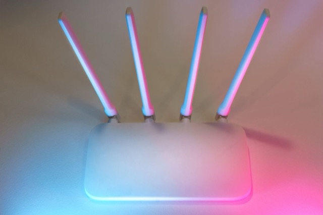 Photograph: white router with four antennas, soft colored light